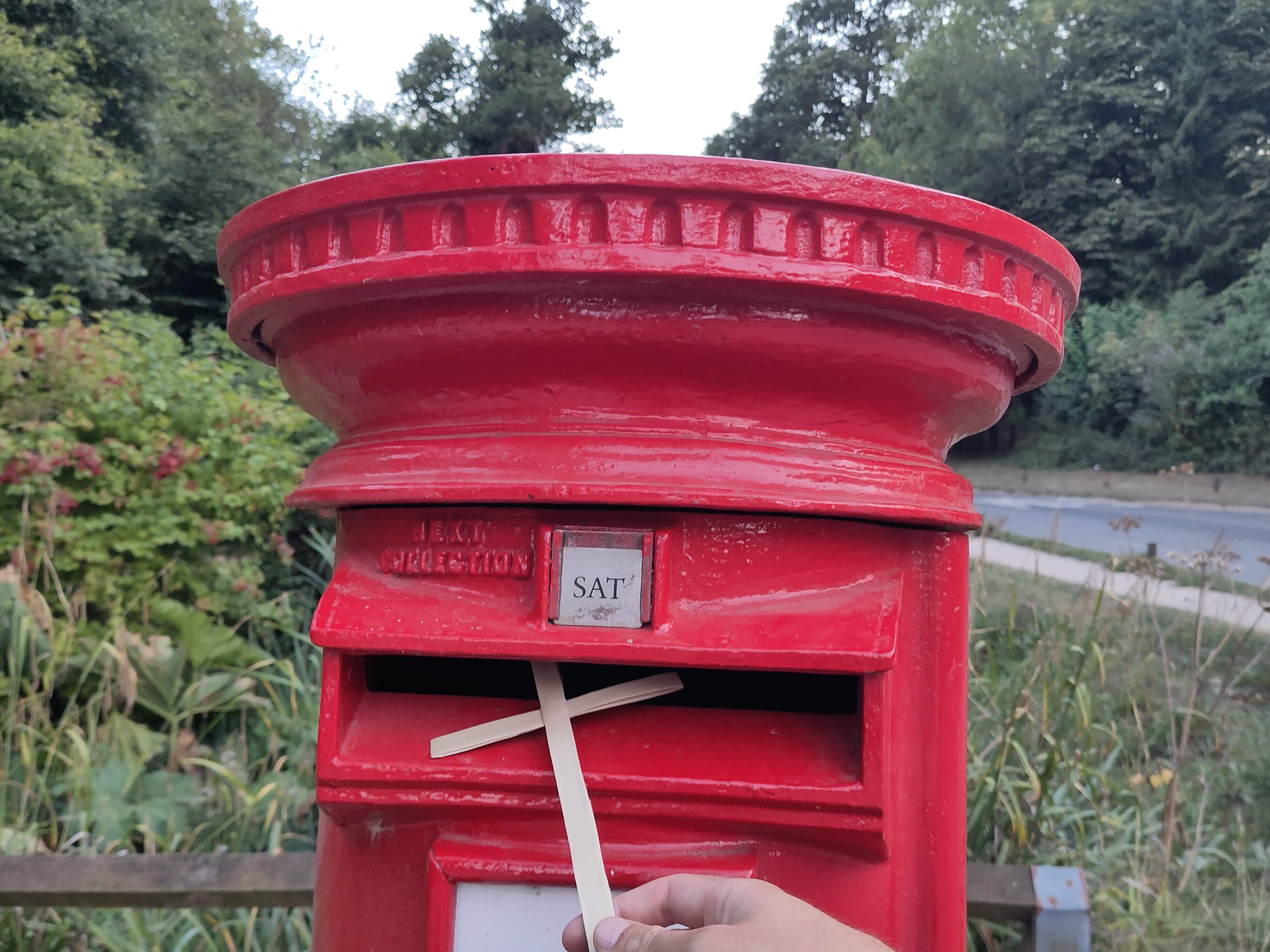 A Palm Sunday cross being placed in a postbox